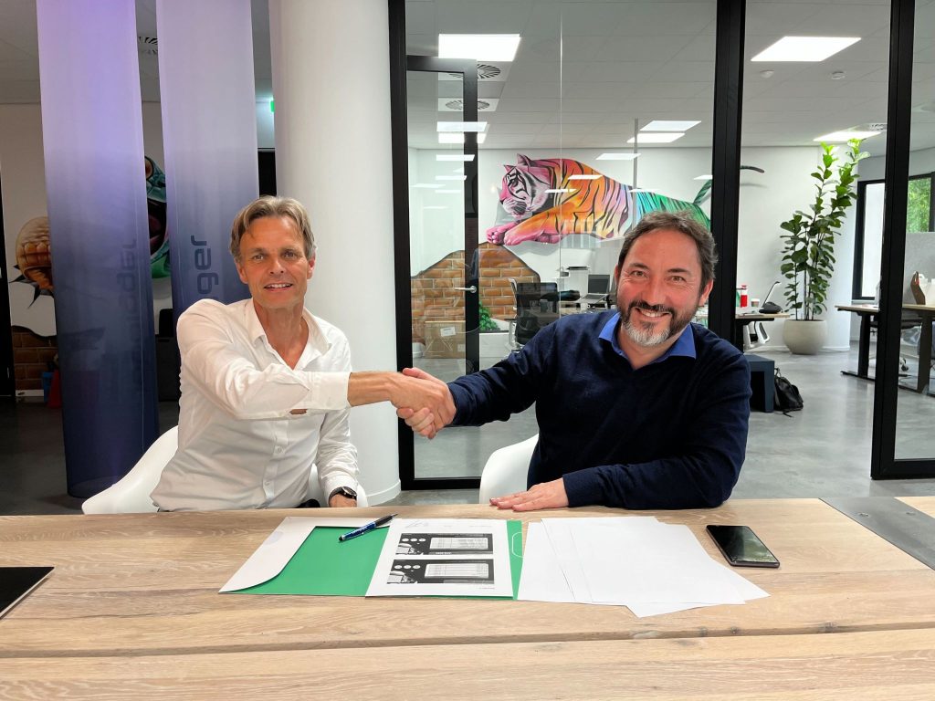 Adelbert en Yves schudden handen na tekenen van het contract